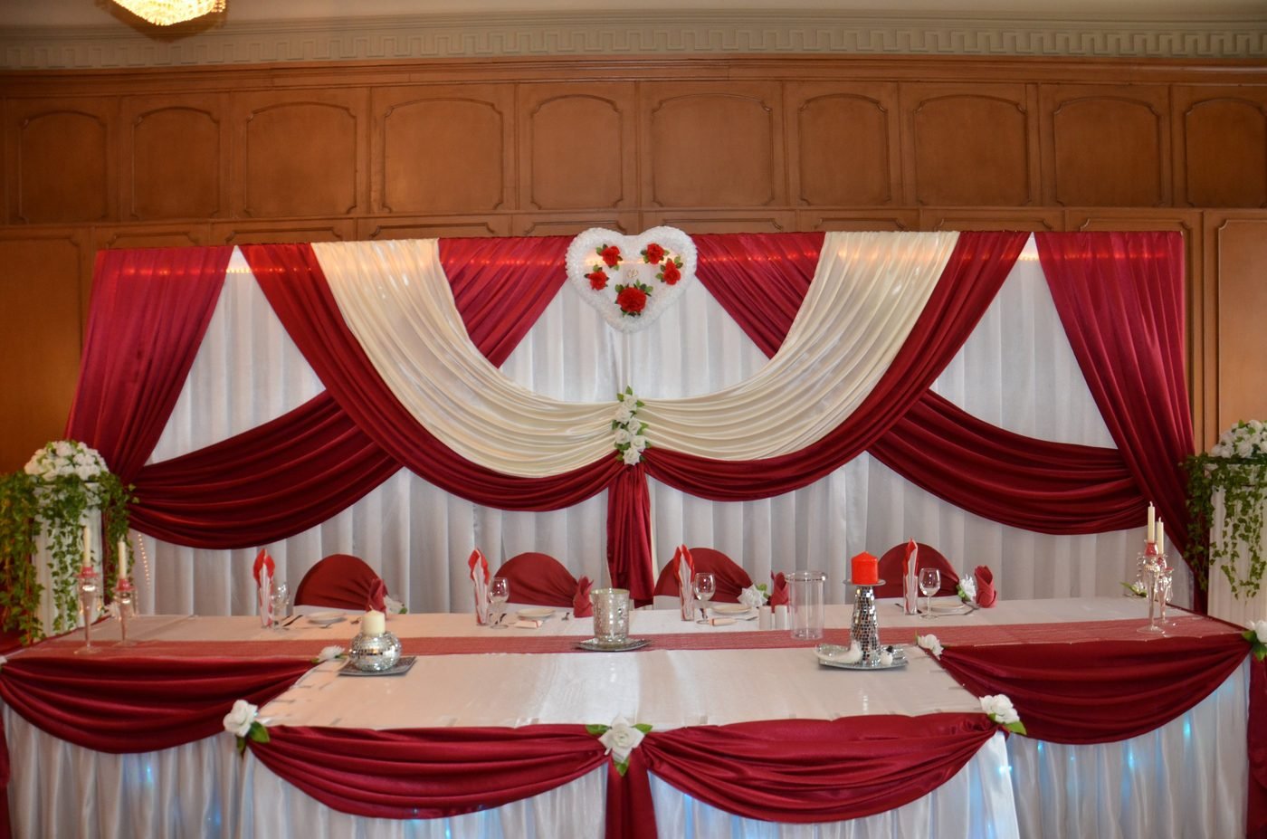 Lange Brauttafel mit Bordeaux-Stoffbahnen und Blumengestecken