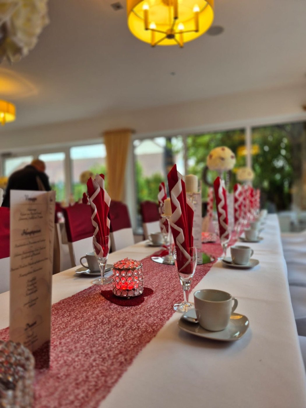 Lange Tafel mit rotem Läufer, Servietten-Fächern und Kristall-Windlicht