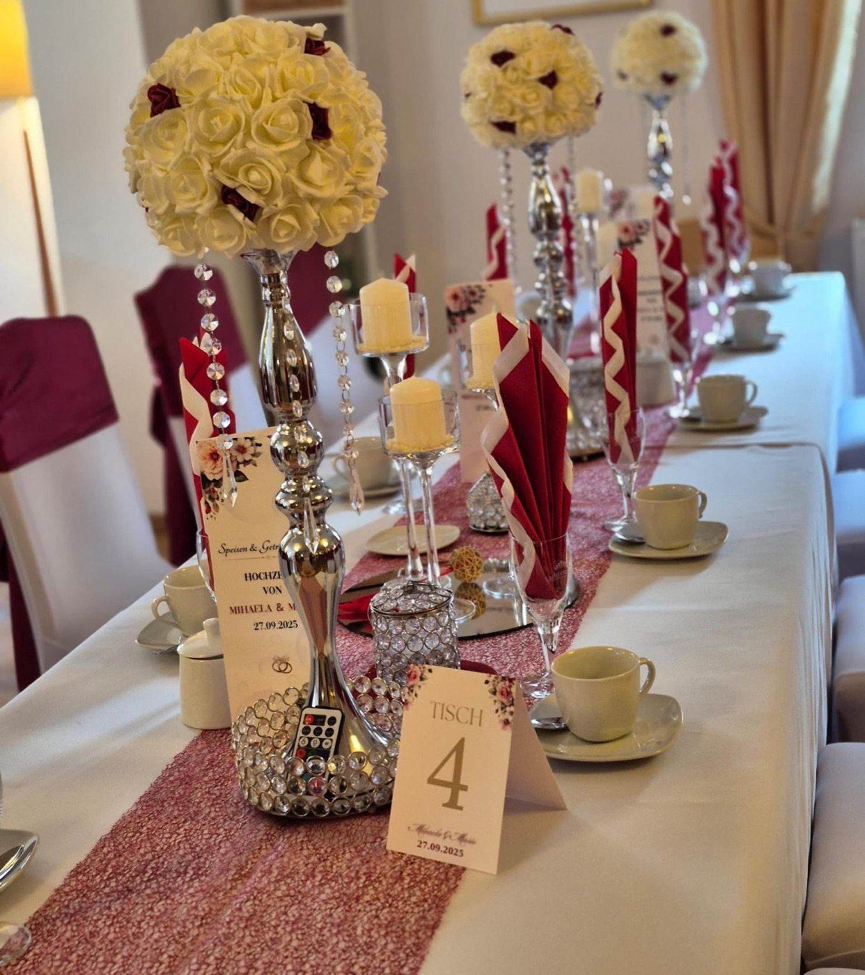 Festtafel mit Rosenkugeln auf Silberständern und Bordeaux-Akzenten