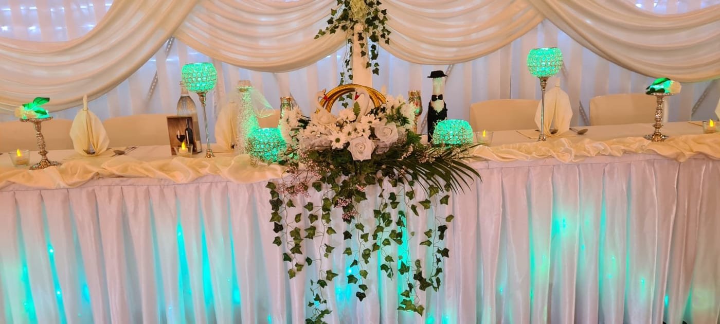 Brauttisch mit Blumengesteck, Laternen und stimmungsvoller Beleuchtung
