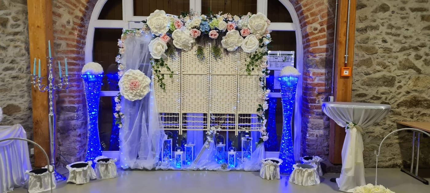 Fotowand mit Papierblumen und blauer Beleuchtung für die Hochzeit