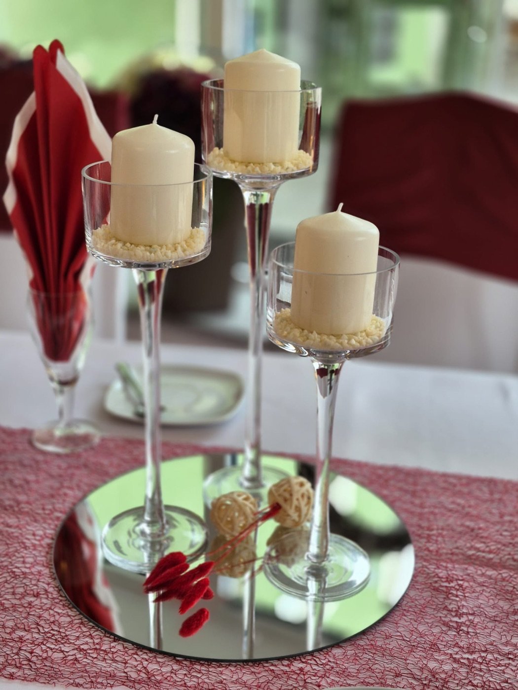 Glas-Kerzenständer mit Stumpenkerzen auf Spiegelplatte