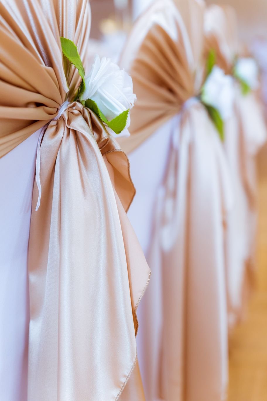 Stuhlhussen mit goldenen Satin-Schleifen und weißen Rosen – elegante Hochzeitsdekoration von Anastasia Dekoration